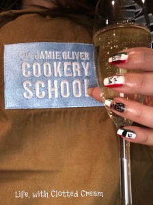 Jamie Oliver Cookery School Apron with glass of prosecco