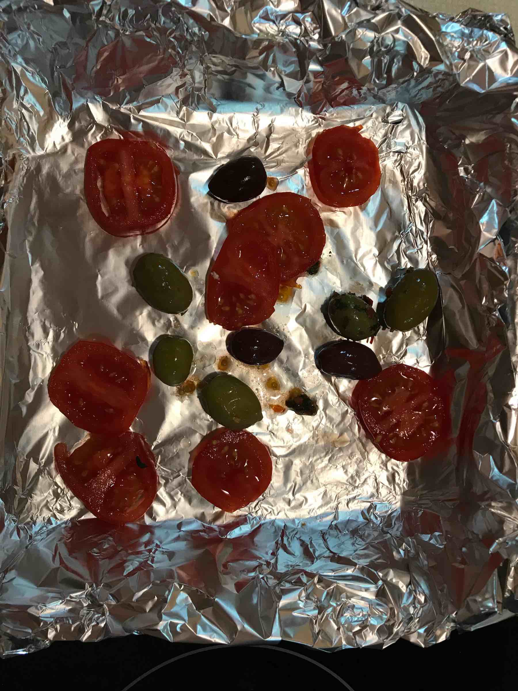 Tomatoes and olives on foil