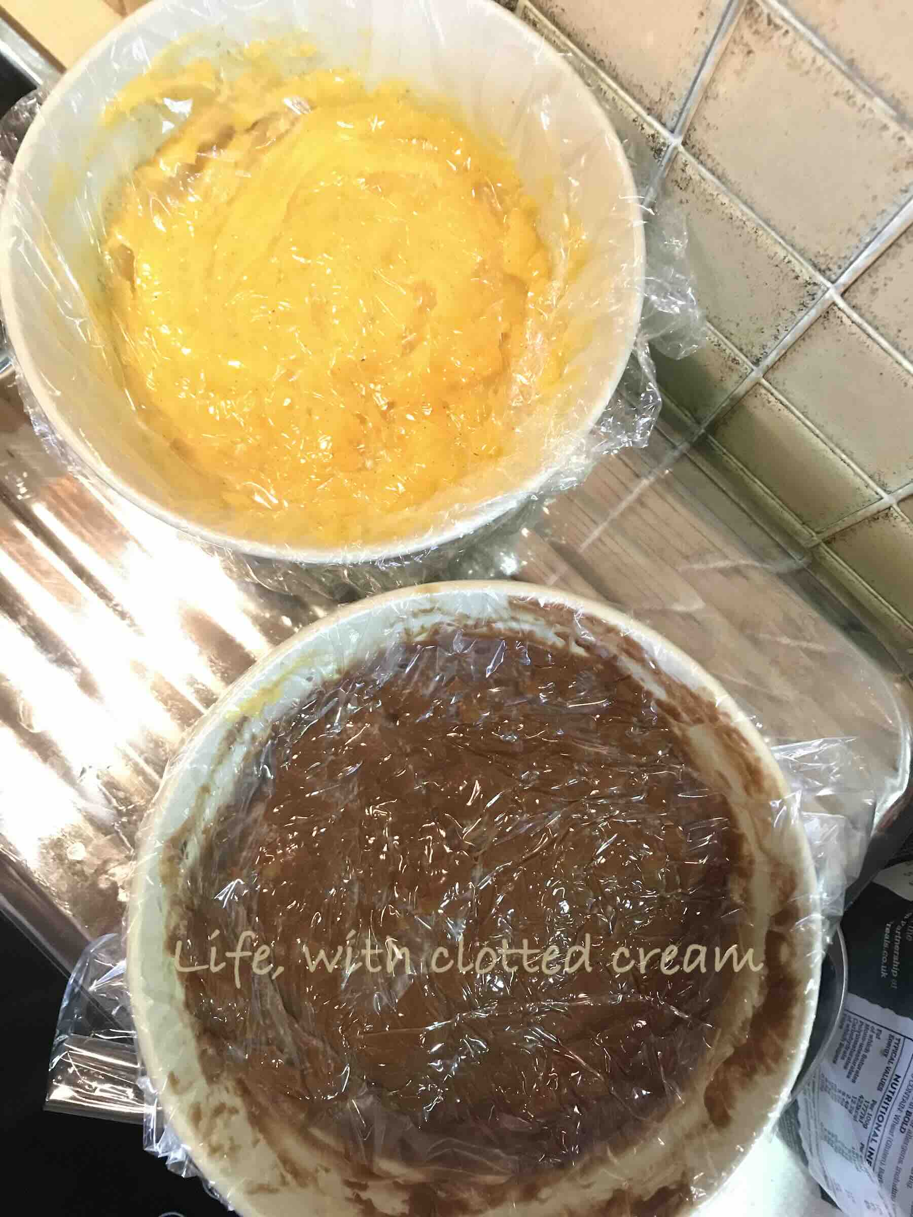 Two bowls of custard, one plain and one chocolate, covered in cling film.