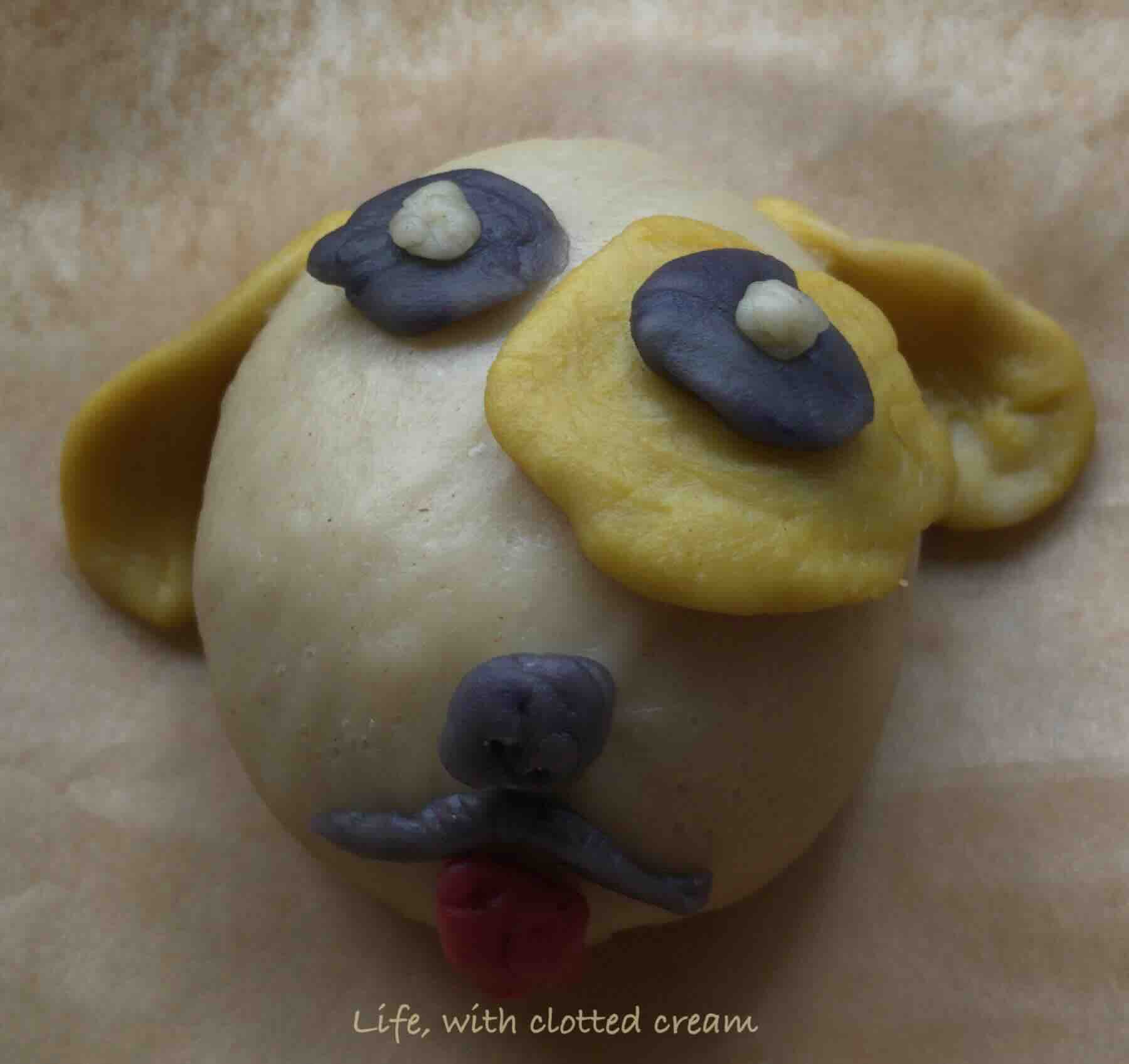 A custard filled bao decorated with the face of a dog.