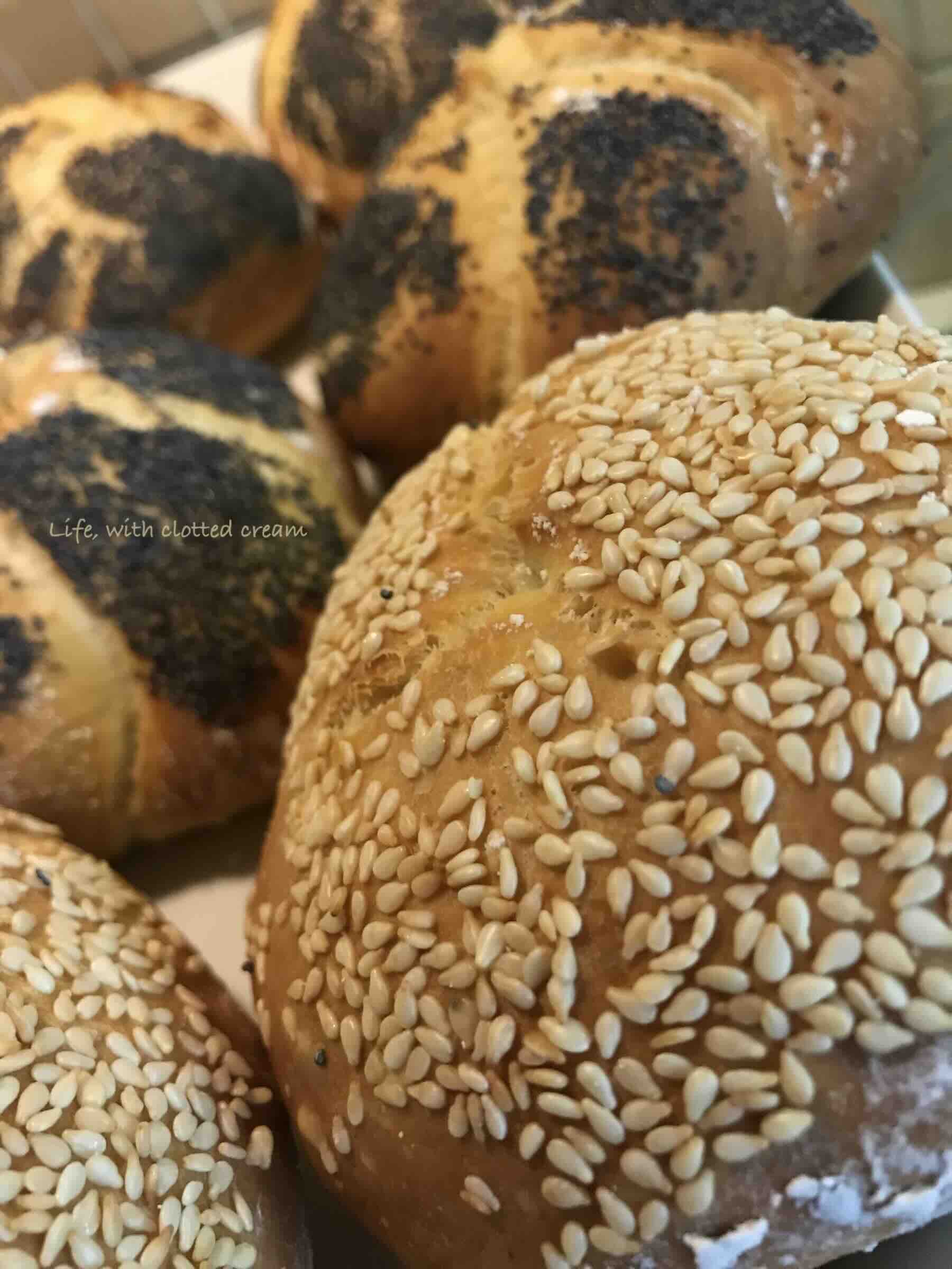Fully baked kaiser rolls on a white platter ready to be served.