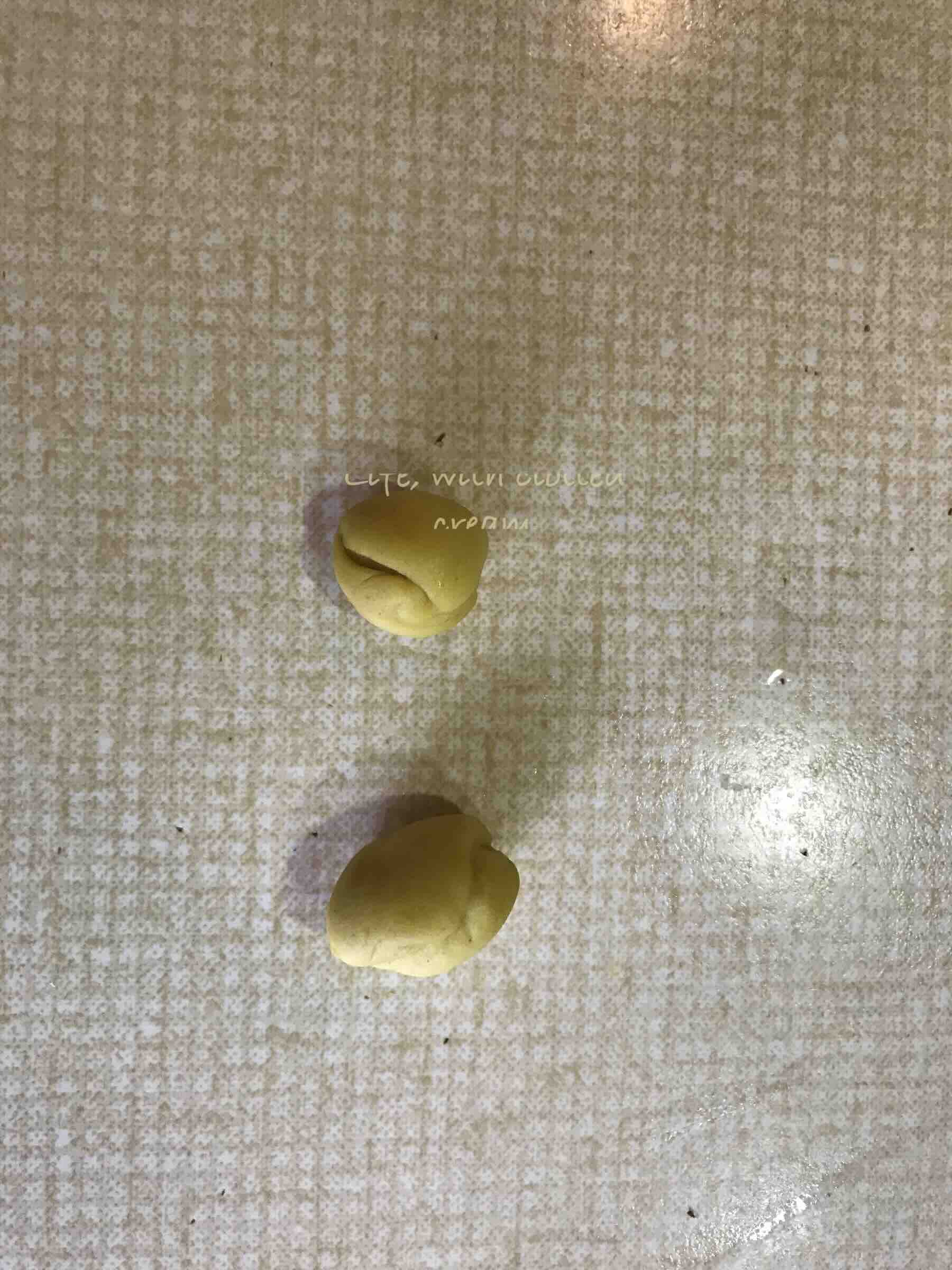 Two balls of dough in a mustard yellow colour.