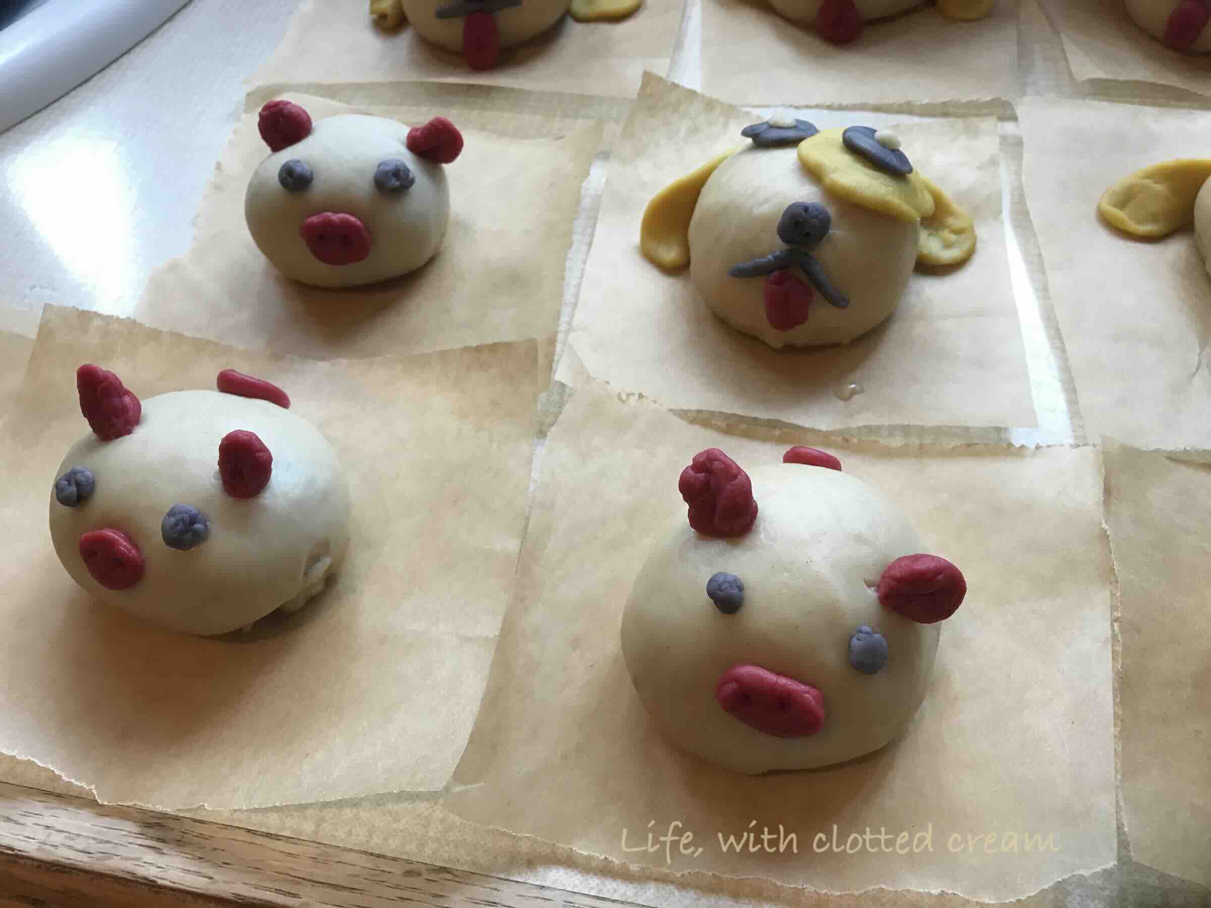 Little piglets and dog bao buns on. parchment before steaming
